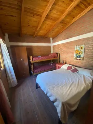 a bedroom with a white bed in a brick wall at Lo de Alicia 3 in Villa Carlos Paz