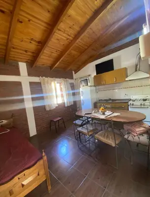 a kitchen with tables and chairs in a room at Lo de Alicia 3 in Villa Carlos Paz
