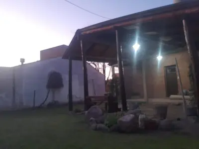 a house with a lit up porch at night at La casa de Milac in Mina Clavero