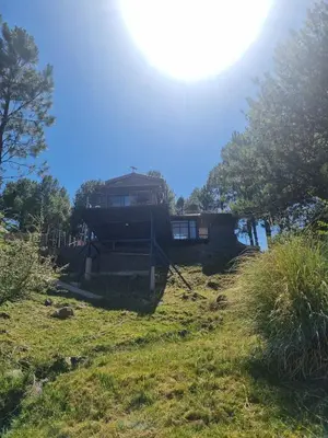 a house sitting on top of a grassy hill at La Colina de Villa Yacanto in Villa Yacanto