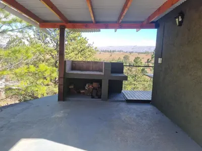 a patio with a bench on the side of a building at La Colina de Villa Yacanto in Villa Yacanto