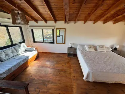 a living room with a bed and a couch at La Colina de Villa Yacanto in Villa Yacanto