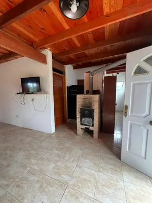 a living room with a fireplace and a tv at cabaña con pileta in Villa Anizacate