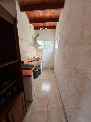a kitchen with a long hallway with a sink and a counter at cabaña con pileta in Villa Anizacate