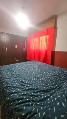 a bedroom with a large bed with red curtains at Arenas Departamentos in Mina Clavero