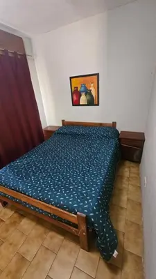 a bedroom with a bed with a blue comforter at Arenas Departamentos in Mina Clavero