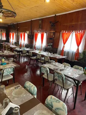 a dining room with tables and chairs and red curtains at Hosteria Rosales in Trapiche