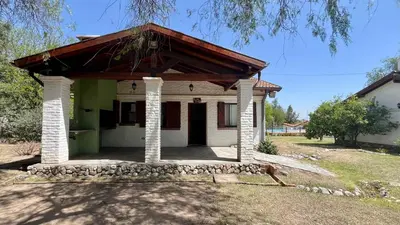 a small white house with a wooden roof at Cabañas Aldea Blanca in Merlo
