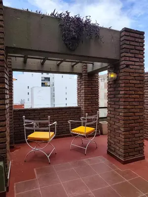 two chairs with yellow cushions sitting on a patio at Departamento en calle Obispo Trejo in Cordoba