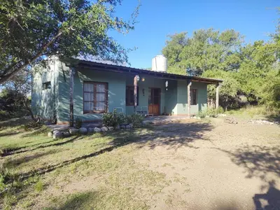 a small blue house with a tree in front of it at Espacio Colibrí in San Francisco del Monte de Oro