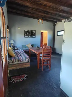 a living room with a table and a bed at Espacio Colibrí in San Francisco del Monte de Oro