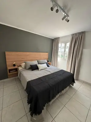 a bedroom with a large bed with a wooden headboard at Calma 1939 in Villa Carlos Paz