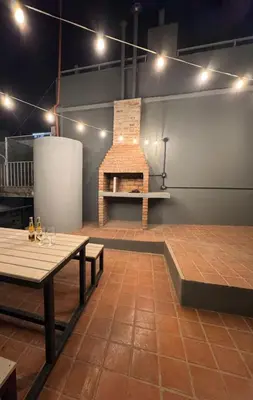 a room with tables and a brick fireplace at Calma 1939 in Villa Carlos Paz