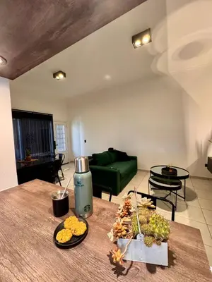a living room with a green couch and a table at Calma 1939 in Villa Carlos Paz