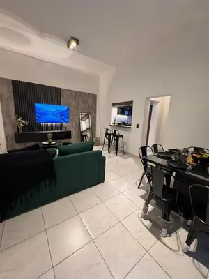 a living room with a green couch and a table at Calma 1939 in Villa Carlos Paz
