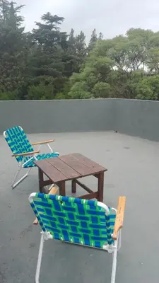 two chairs and a wooden table and two chairs at Departamento en Villa del Lago, Carlos Paz in Villa Carlos Paz