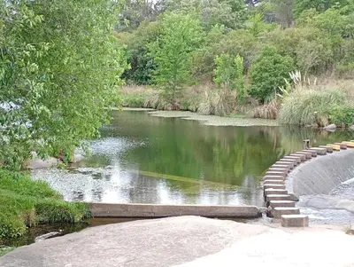 a river with a bridge in the middle of it at Departamento en Villa del Lago, Carlos Paz in Villa Carlos Paz