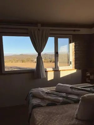 a bedroom with two beds and a window at Terraza de Amancay in Villa Amancay