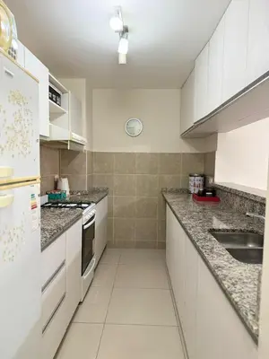a white kitchen with a sink and a counter top at Reggia house in Cordoba