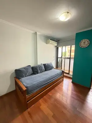 a couch in a room with a clock on the wall at Jacaranda apart in Cordoba