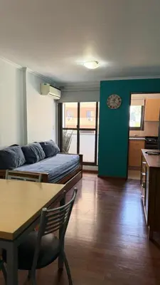 a room with a bed and a table and a kitchen at Jacaranda apart in Cordoba