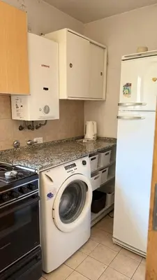 a kitchen with a washing machine and a refrigerator at Jacaranda apart in Cordoba