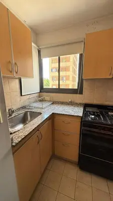 a kitchen with a sink and a stove and a window at Jacaranda apart in Cordoba