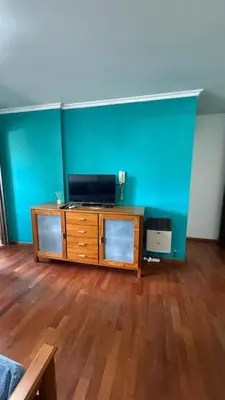 a living room with a tv on a wooden dresser at Jacaranda apart in Cordoba