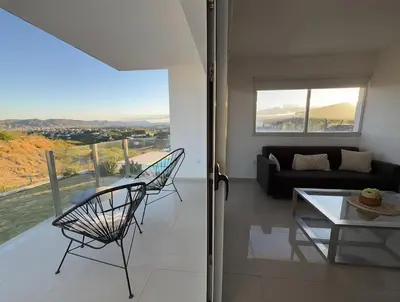 a living room with a couch and a table and chairs at Departamento Carilo Carlos Paz in Villa Carlos Paz