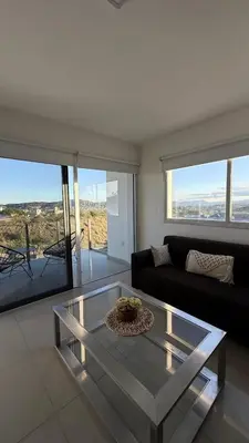 a living room with a couch and a glass table at Departamento Carilo Carlos Paz in Villa Carlos Paz