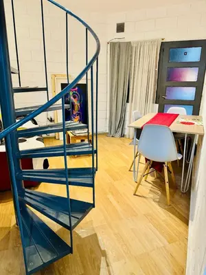 a blue spiral staircase in a room with a table at Encantador departamento en Güemes in Cordoba
