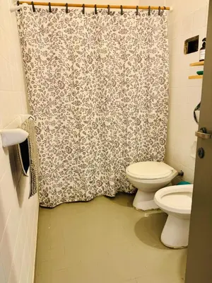 a bathroom with a toilet and a shower curtain at Encantador departamento en Güemes in Cordoba