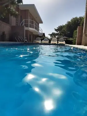 a swimming pool in front of a building at Hotel Dormi's Solo Adultos in Mina Clavero
