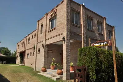 a brick building with a sign in front of it at Hotel Dormi's Solo Adultos in Mina Clavero