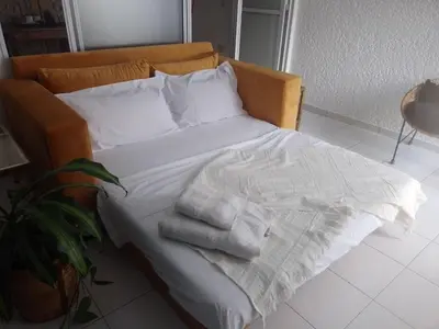 a bed with white sheets and towels on it at Estudio en Nueva Córdoba in Cordoba
