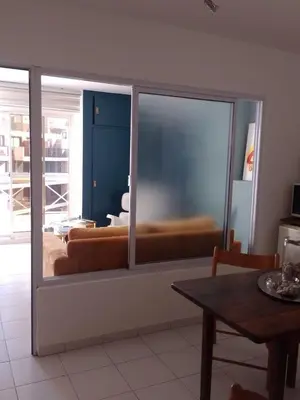 a living room with a large glass window with a couch at Estudio en Nueva Córdoba in Cordoba