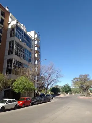 a parking lot with cars parked in front of a building at Estudio en Nueva Córdoba in Cordoba