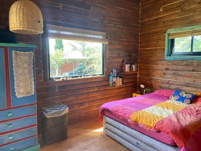 a bedroom with a bed in a wooden room at Cabaña frente al lago in La Estancia