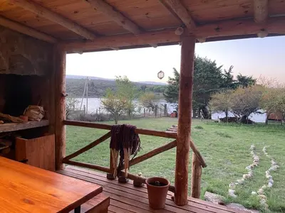 a porch of a cabin with a view of a field at Cabaña frente al lago in La Estancia