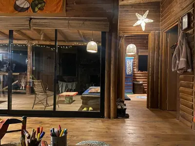 a room with a large glass window and a table at Cabaña frente al lago in La Estancia