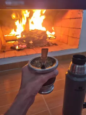 a hand holding a cup of coffee in front of a fire at Casa de Tanti in Tanti