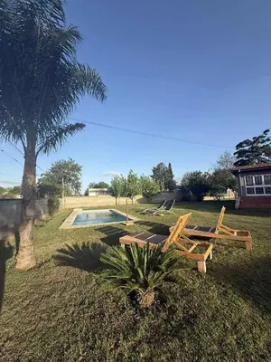 a picnic table and bench next to a palm tree at Depto Santa Cruz in Villa Santa Cruz del Lago