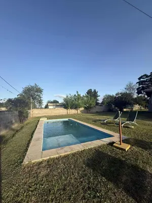 a small swimming pool in a yard with two chairs at Depto Santa Cruz in Villa Santa Cruz del Lago