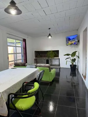 a living room with a table and green chairs at Depto Santa Cruz in Villa Santa Cruz del Lago