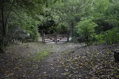 a gate in the middle of a field with trees at NATURAL Tanti Lomas in Tanti