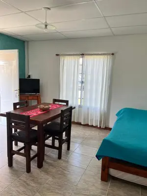 a dining room with a table and chairs and a bed at Cabañas La Chakana in Cortaderas