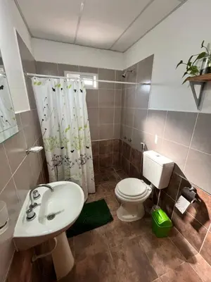 a bathroom with a sink and a toilet and a shower at Cabañas La Chakana in Cortaderas