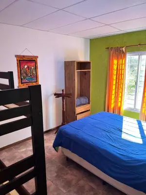 a bedroom with a blue bed and a window at Cabañas La Chakana in Cortaderas
