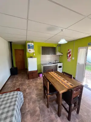 a kitchen with a wooden table in a room at Cabañas La Chakana in Cortaderas