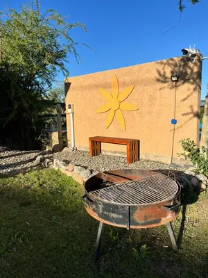 a grill in front of a building with a sign on it at Cabañas La Chakana in Cortaderas